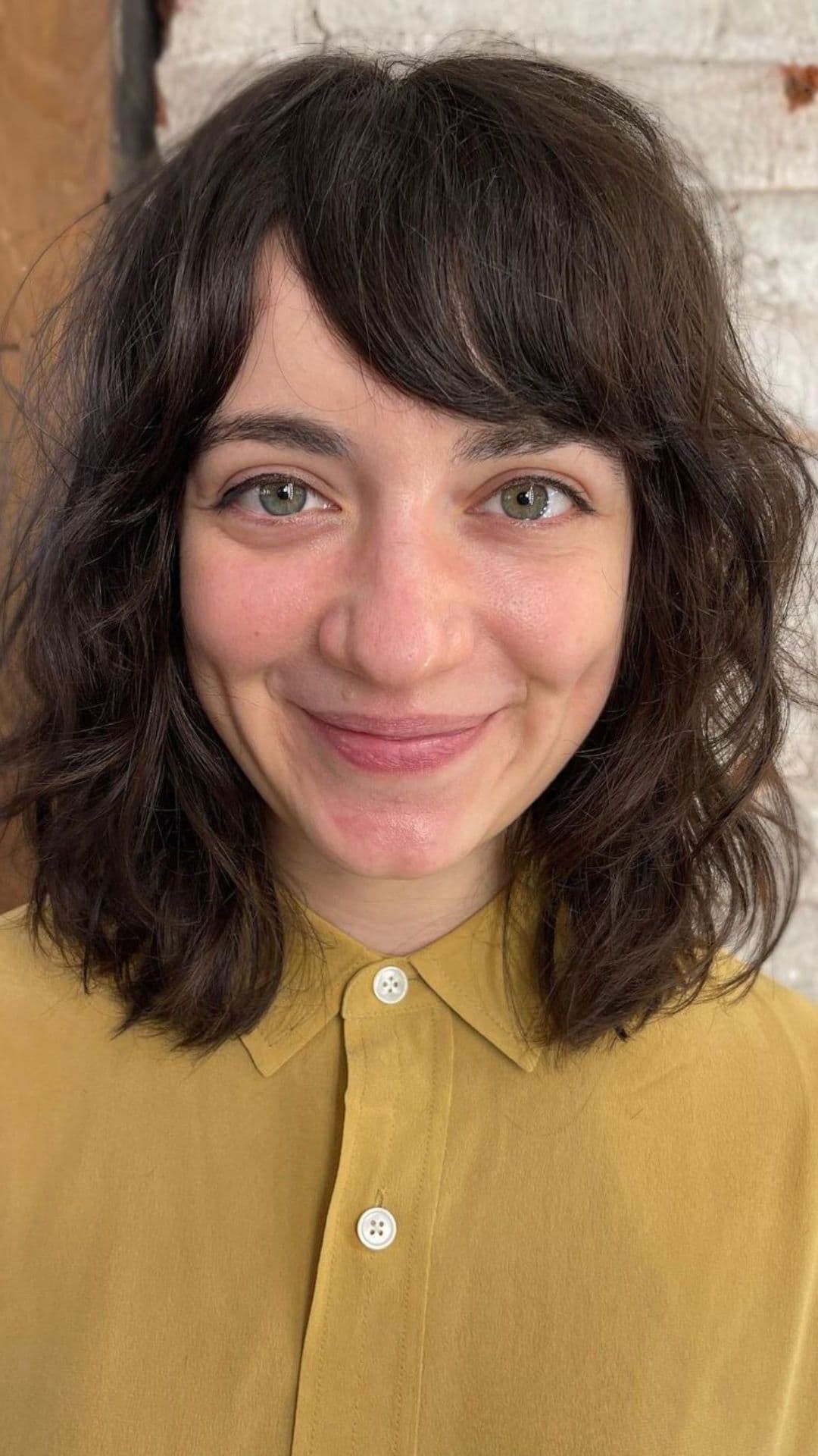 A woman modelling a shaggy shoulder-length bob with side swept bangs.