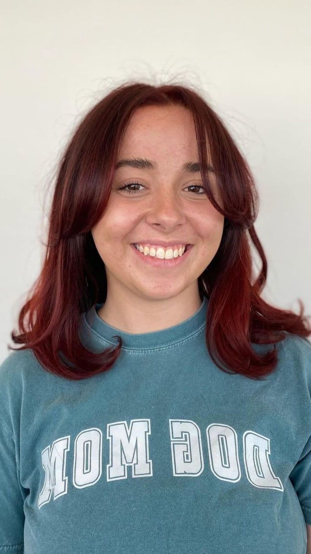 A woman modelling a shoulder-length hair and curtain bangs.