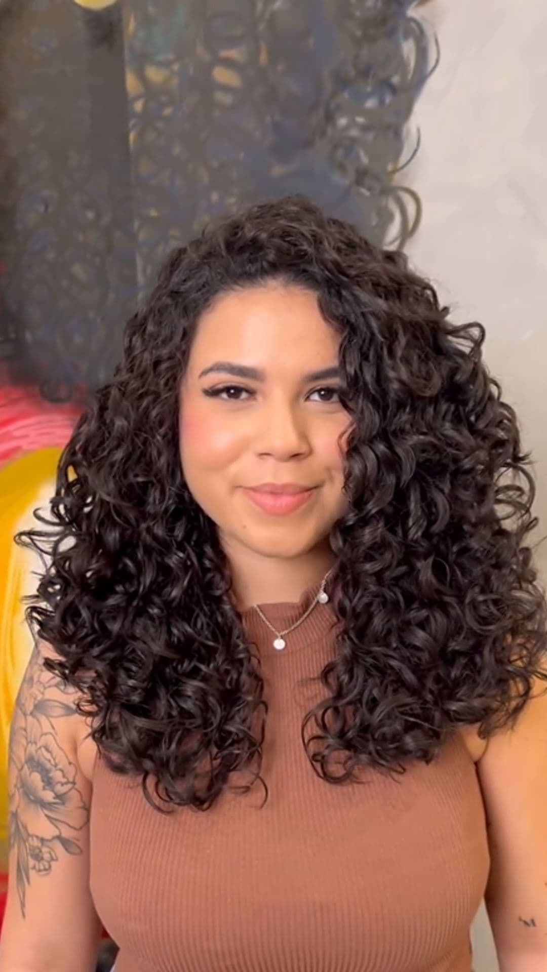 A woman modelling a curly hairstyle for medium-length hair.